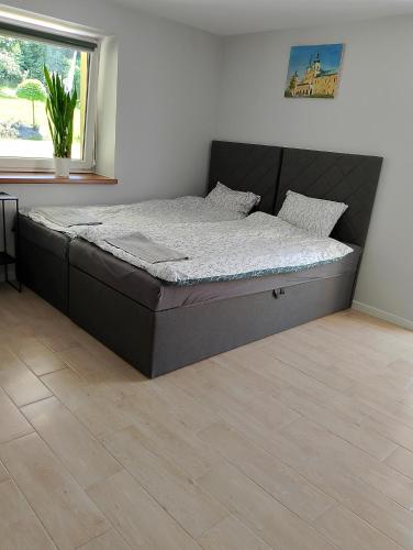 a bed in a bedroom with a wooden floor at Apartament z ogrodem in Przemyśl