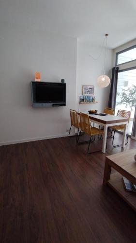a living room with a table and chairs and a tv at Casinha Secreta - A Gema Escondida da Santa Luzia in Santa Luzia