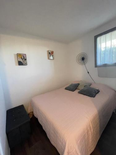 une chambre avec un lit blanc et une fenêtre dans l'établissement Parenthèse au bord de l'eau, à Port-la-Nouvelle