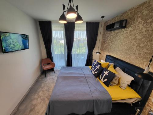 Un dormitorio con una cama con almohadas amarillas. en Sea view luxury appartment-parking, en Varna