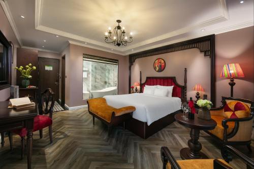 a bedroom with a large bed and a desk at Acoustic Hotel & Spa in Hanoi