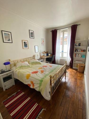 une chambre avec un lit avec un couvre-lit fleuri dans l'établissement Near Paris, charming quiet sunny 2 rooms, à Pantin