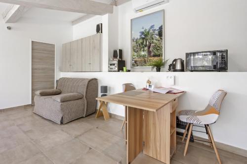 - une cuisine avec une table, une chaise et un bureau dans l'établissement Studio Les Cyclamens- Les Oliviers, à Saint-Raphaël