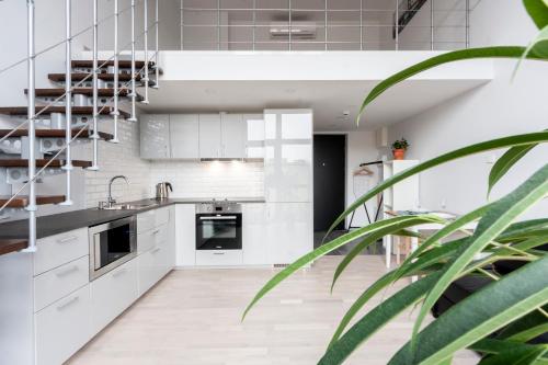 a kitchen with white cabinets and a potted plant at Uptown Lofts in Vilnius