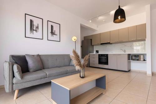 a living room with a couch and a table and a kitchen at Phaedrus Living Limassol Pyrgos Seaside Flat in Limassol