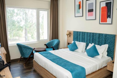 a hotel room with a bed and two chairs at Hotel W Grand - A Boutique Hotel in Haridwār