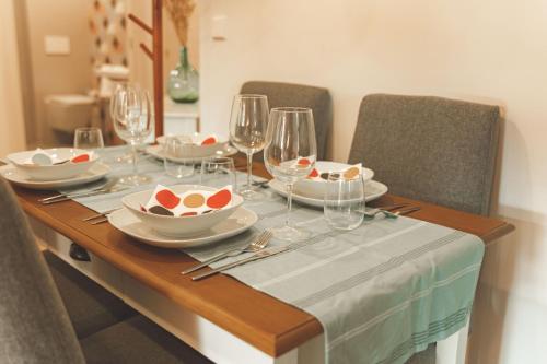 a table with plates and wine glasses on it at Casa Rural Passivhaus Kostoenea in Hondarribia