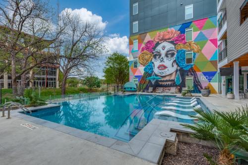 a mural on the side of a building with a pool at Modern Cozy Condo facing Riverwalk w King Suite in San Antonio