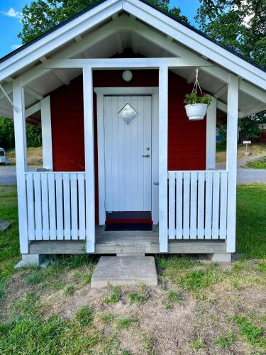 a red and white shed with a door and a flower pot at Skeppsdockans Vandrarhem in Söderköping