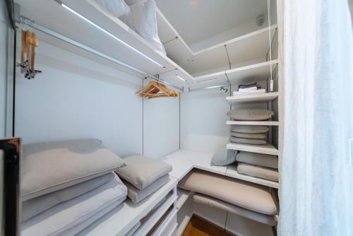 a walk in closet with white shelves and pillows at Luxury Waterfront Villa at Dukly Gardens in Budva