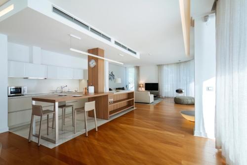 a kitchen with white cabinets and a table and chairs at Luxury Waterfront Villa at Dukly Gardens in Budva