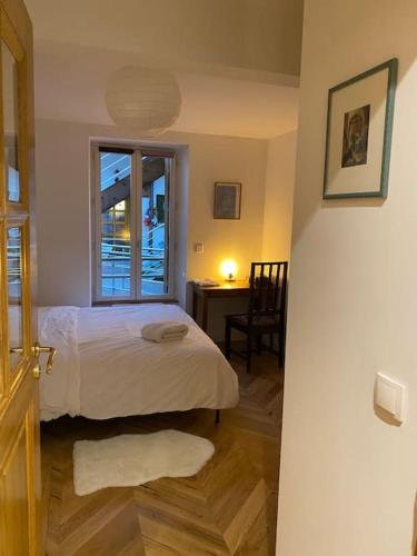 une chambre avec un lit, un bureau et une fenêtre dans l'établissement Charming fully renovated flat in old-town, à Ferney-Voltaire