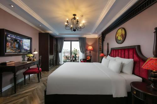 a bedroom with a large white bed and a desk at Acoustic Hotel & Spa in Hanoi