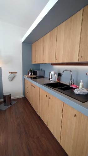 a kitchen with wooden cabinets and a sink at Casinha Secreta - A Gema Escondida da Santa Luzia in Santa Luzia