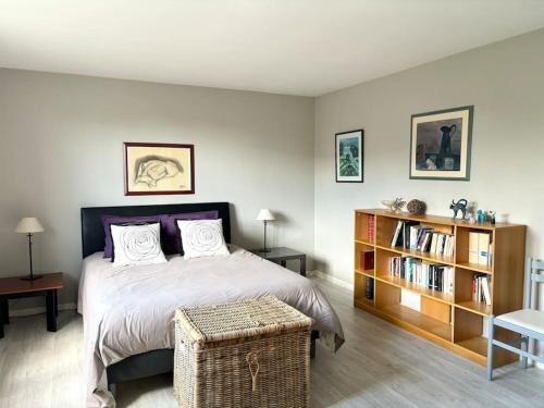 une chambre avec un lit et une étagère dans l'établissement Belle maison familiale - Proche Golf National, à Montigny-le-Bretonneux