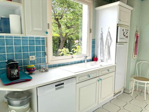 une cuisine avec un évier et une fenêtre dans l'établissement Belle maison familiale - Proche Golf National, à Montigny-le-Bretonneux