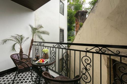 a balcony with chairs and a table with a bowl of fruit at Acoustic Hotel & Spa in Hanoi