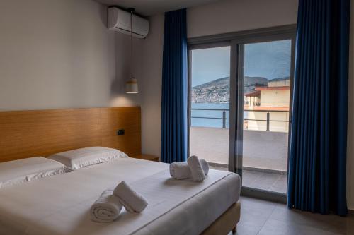 a bedroom with a bed and a large window at Franklin Rooms in Sarandë