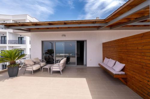 a patio with a couch and chairs and a table at Franklin Rooms in Sarandë