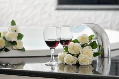 two glasses of wine and a bouquet of white roses at M Hotel in Caotun
