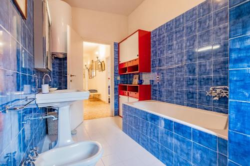 uma casa de banho em azulejos azuis com uma banheira e um lavatório em Tenuta Bussadori - Casa Del Maresciallo em Poggio