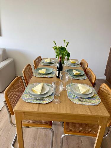 a wooden table with plates and napkins on it at AM3Office apartment Lausanne new, cozy, central, fast Wi-Fi & contactless check-in in Prilly