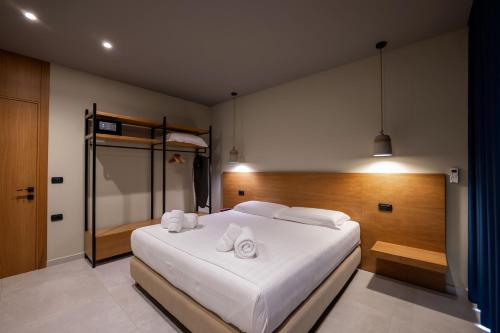 a bedroom with a large white bed with two towels at Franklin Rooms in Sarandë