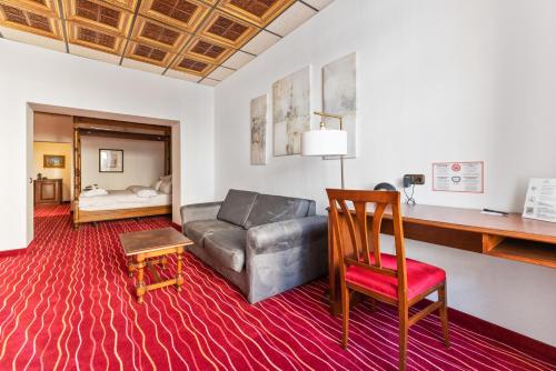 a living room with a couch and a desk at KING's Hotel First in Munich