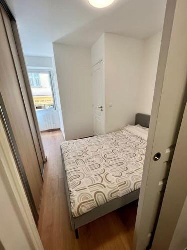 une petite chambre avec un lit et une fenêtre dans l'établissement Appartement de charme au cœur de la vielle ville, à Villefranche-sur-Mer