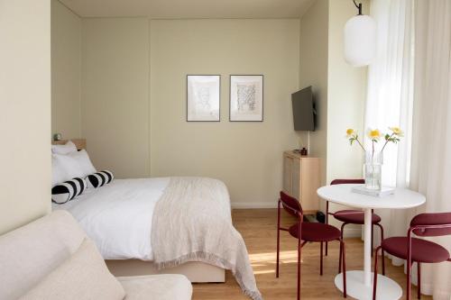 a bedroom with a bed and a table and chairs at Bob W Turku City Centre in Turku