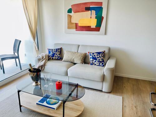 a living room with a couch and a glass table at AM3Office apartment Lausanne new, cozy, central, fast Wi-Fi & contactless check-in in Prilly