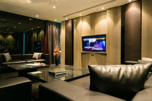 a living room with a couch and a tv at M Hotel in Caotun