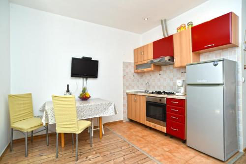 a kitchen with a table and a refrigerator at Apartments Magdalena 759 in Valbandon