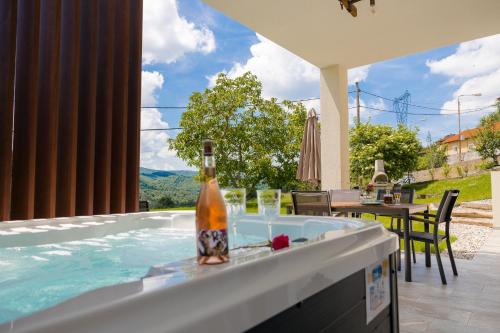 a bottle of wine sitting on top of a swimming pool at Brkinka Apartments in Vremski Britof