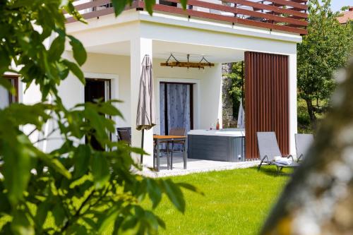 a house with a garden with a table and an umbrella at Brkinka Apartments in Vremski Britof