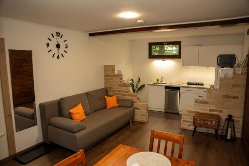 a living room with a couch and a kitchen at Zsófi Vendégház in Szekszárd
