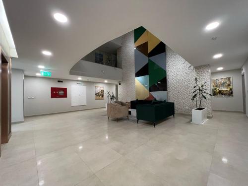 a living room with a couch and paintings on the wall at Addis Ville Hotel Apartment in Addis Ababa