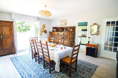 une salle à manger avec une table et des chaises blanches dans l'établissement -BALUM-MAISON FAMILIALE JARDIN Á 150M DES PLAGES, à Concarneau