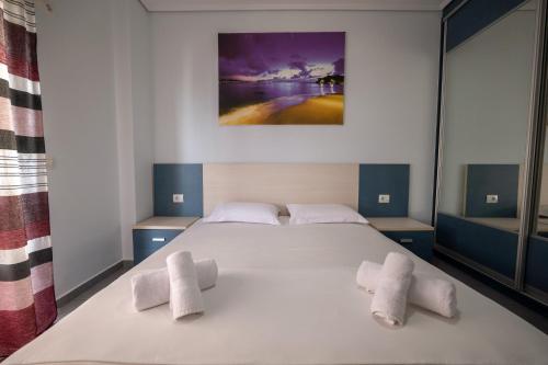 a bedroom with a white bed with towels on it at Franklin Rooms in Sarandë