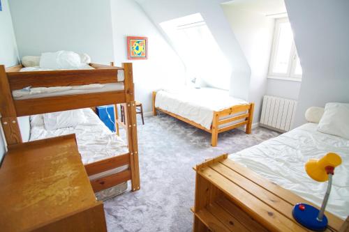 une chambre avec deux lits superposés et une table dans l'établissement -BALUM-MAISON FAMILIALE JARDIN Á 150M DES PLAGES, à Concarneau
