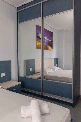 a bedroom with a mirror and a bed with towels at Franklin Rooms in Sarandë