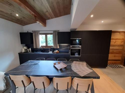 une cuisine avec une table et des chaises dans une pièce dans l'établissement Chalet Claudia by Brennus Chamonix, à Chamonix-Mont-Blanc
