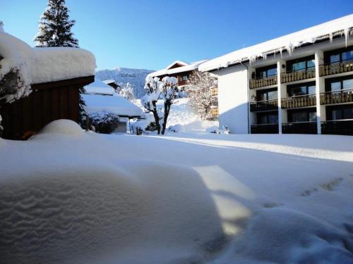 a snow covered parking lot in front of a building at Haus Obermaiselstein in Obermaiselstein