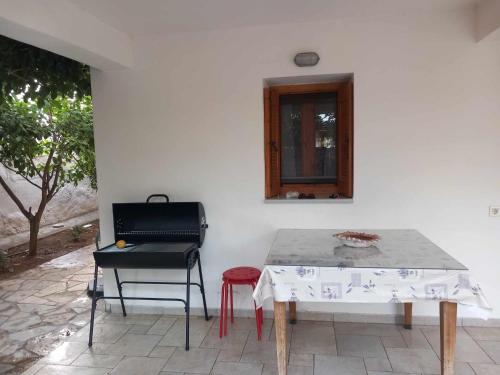 a table and a chair next to a white wall at traditional village house in Ariokhórion