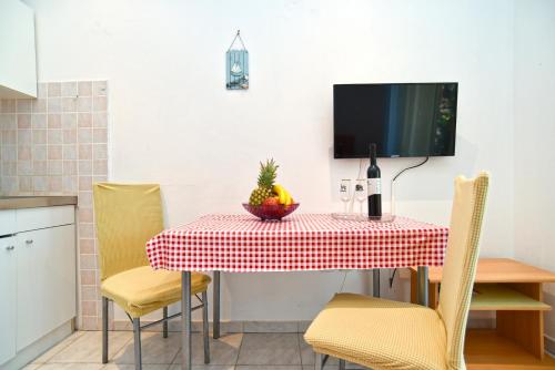 a table with a bowl of fruit and a bottle of wine at Apartments Magdalena 759 in Valbandon
