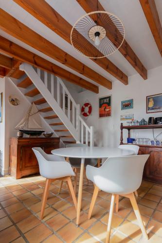 une salle à manger avec une table et des chaises blanches dans l'établissement Gîtes Ty Kelen, à Combrit