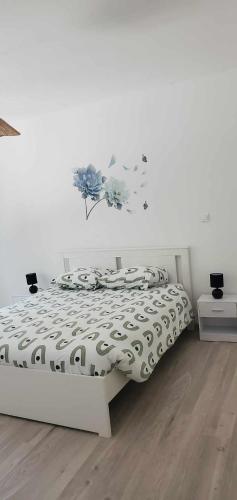 a bedroom with a white bed with a black and white comforter at au Bonhomme de Chemin in Saint-Martin-de-Ribérac