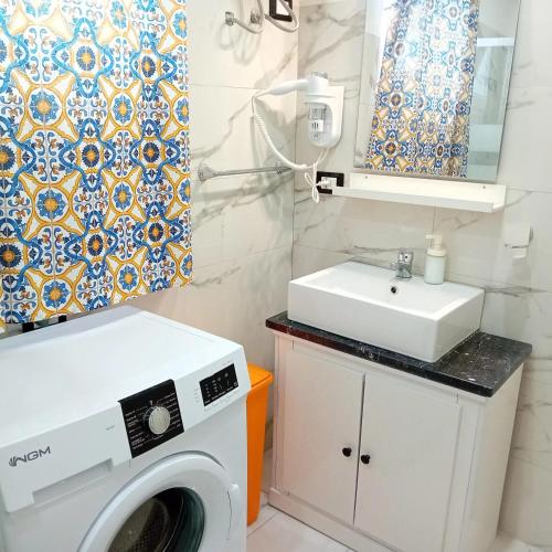 a bathroom with a washing machine and a sink at Oasi del mare in Granelli
