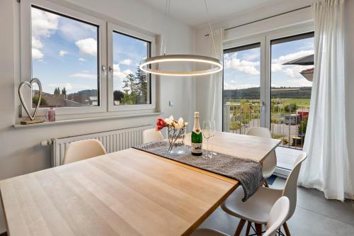 a dining room with a table and chairs and windows at Schmuckstück in Hilzingen
