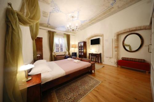 a bedroom with a large bed and a mirror at Petrizio Palace in Zadar